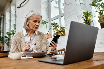 A mature woman with beautiful gray hair savors her meal and checks her smartphone at a cozy table.