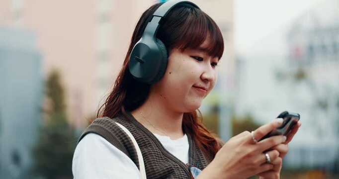Woman, student and phone with headphones in city for thinking, schedule or travel to university. Person, girl and listen to music on smartphone, outdoor and mobile app for journey to college in Japan