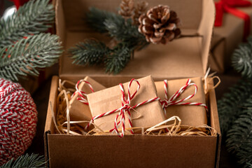 Christmas or New Year's gifts in craft packaging in a gift box on a festive table close-up