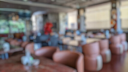 Defocused abstract background of cafe or restaurant interior design. Wooden table, wooden chairs and empty sofa in elegant and luxurious style with blur background. Cafe interior concept