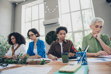 Photo of four diverse women businessladies feminists community working together comfortable modern office room interior indoors workspace