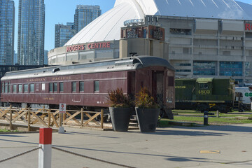 Naklejka premium Rogers Centre and vintage carriage railcar at The Toronto Railway Museum / Roundhouse Park, 255 Bremner Blvd, downtown