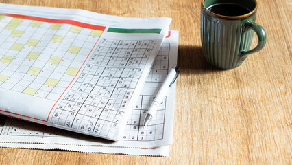 crossword paper with pen and coffee cup