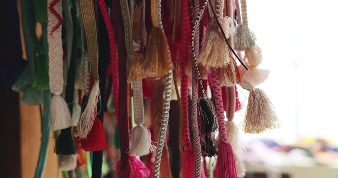 Japan, kimono decoration and obi belt in fabric shop with embroidery pattern and waistband tassel. Small business, textile wrap and handmade craft in market with cultural designs and closeup texture