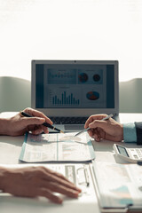 Team of data analysts with laptops and financial graph documents in hand With online reviews Meet...