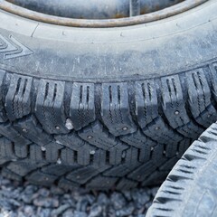 Close-up shot of car wheels lying on gravel.