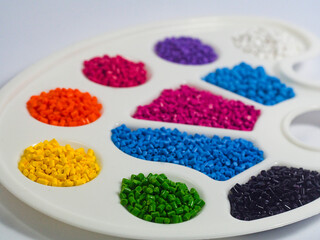 Assorted color masterbatch granules in pallete isolated on white background, polymer carrier of...