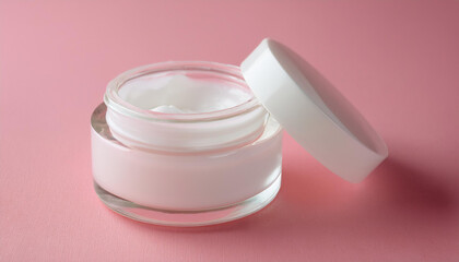 Glass cream jar with white lid on pink surface. Cosmetic product. Beauty and skin care routine.