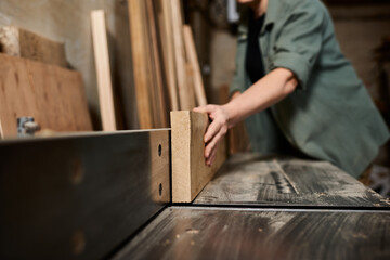 A skilled carpenter focuses intently on crafting wood in her workshop, showcasing craftsmanship and dedication.
