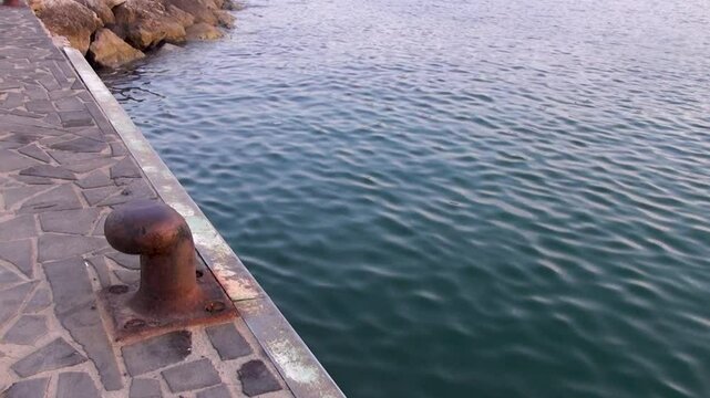 One the bollards along the wharf in the port.  A rusty bitt.