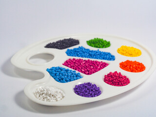 Assorted color masterbatch granules in pallete isolated on white background, polymer carrier of color pigments in plastics industry,perfect for catalog design and plastic industry company profiles