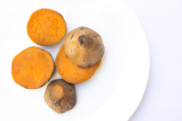 Sliced sweet potatoes isolated on a white plate. Rich in antioxidants, particularly beta-carotene...