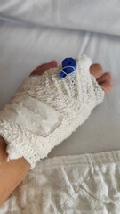 close up focus of kids hand wrapped with bandage and branula