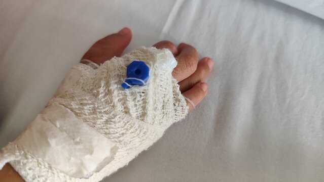 close up focus of kids hand wrapped with bandage and branula