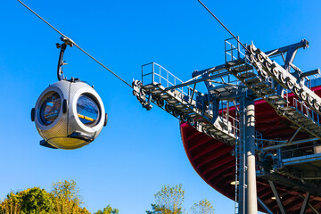 a cable car with round passenger cabins.  cable car against blue sky. aerial tram station