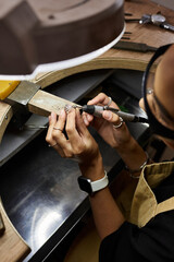 A skilled artisan delicately shapes beautiful jewels in a cozy workshop filled with tools.