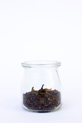 Dried black tea leaves in the jar isolated on white background. Black tea may promote a healthy gut by supporting beneficial bacteria while inhibiting harmful bacteria.
