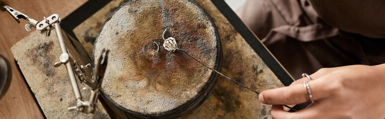A talented craftsman meticulously shapes a stunning jewel with skilled hands in a workshop.