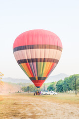 Hot air balloon over yellow flower fields against blue sky,Colorful Hot air balloons flying over the valley with blue sky,Travel and Tourism concept.