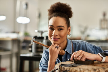 A talented woman focuses on her craft as she designs exquisite jewelry with a hammer.