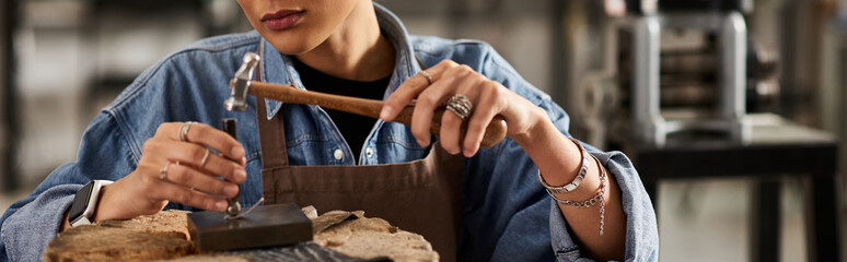 A talented woman meticulously designs stunning jewelry within a well lit workshop space.