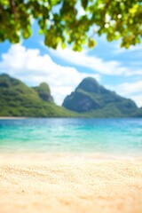 Fototapeta premium Serene sandy beach with vibrant blue water and lush green mountains in the background, perfect for travel blogs, beach resort promotions, or relaxation-themed content,