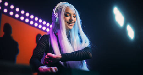 Beautiful DJ Girl Energetically Performing at Nightclub with a Colorful Animated LED Screen Behind Her. Pop Idol Creating a Unique Show Experience with Dynamic Visuals and Powerful EDM Music