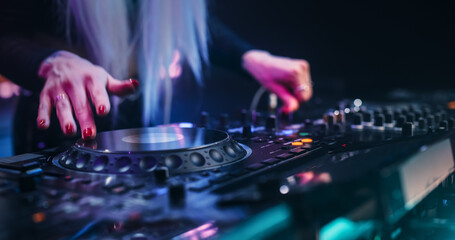 Female DJ Performing Live on Stage, Mixing Tracks With Professional Equipment. Close Up Shots of...