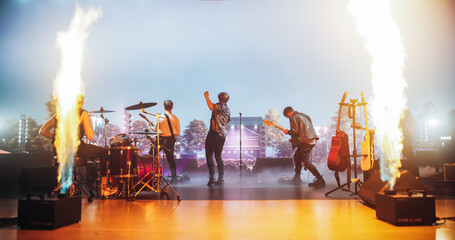 Energetic Rock Band Performing on Festival Stage with Fire Pyrotechnics Special Effects. Rock Music...