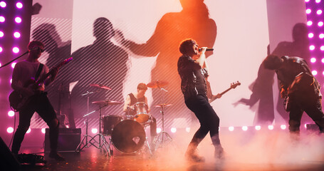 Talented Rock Band Performing a Live Set on an Indoors Stage with Visual Art Display. Young...