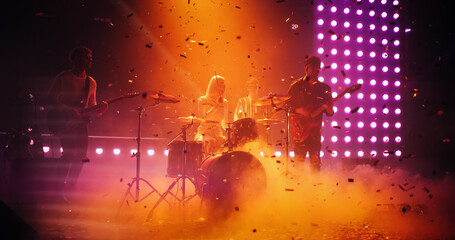 Charismatic Drummer Girl Playing Drums at a Live Band Performance Under Falling Confetti. Young Indie Band Playing Rock Music with Alternative Punk Tracks at a Festival with Energetic Visuals