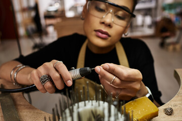 An artist meticulously shapes beautiful jewels, showcasing skill and creativity in her craft.