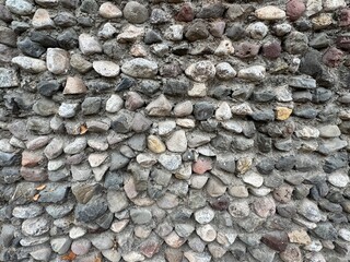 Stone texture of wall background. Grunge stone texture, pattern wallpaper and background. Natural contrast wall rock granite with colorful stones. The space between the stones is filled with cement.