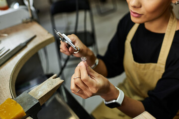 An artist meticulously shapes exquisite jewelry while surrounded by elegant tools and materials.