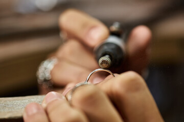 Artisan works meticulously on a silver ring, emphasizing the beauty of intricate jewels.