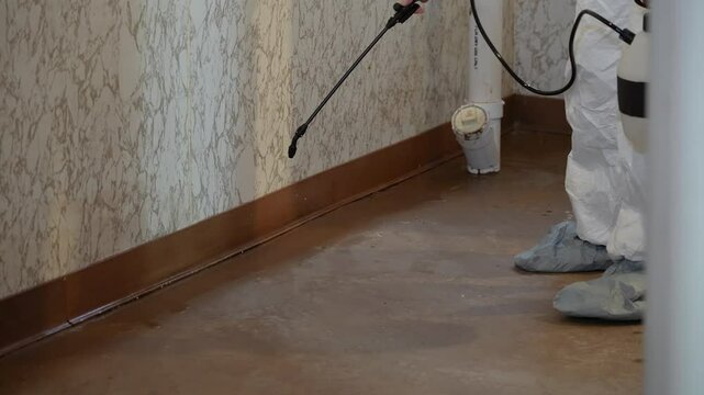 A close up view of a contractor fumigating a household basement to prevent insects from entering the building and foundation.  	