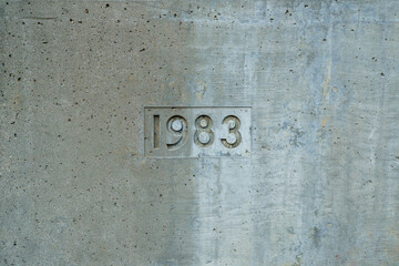 The year 1983 is carved into a concrete wall