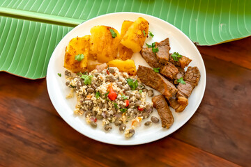 Traditional rustic tropical Brazilian dish, sun-dried beef with green beans, cassava, biquinho pepper. Creative rustic photography