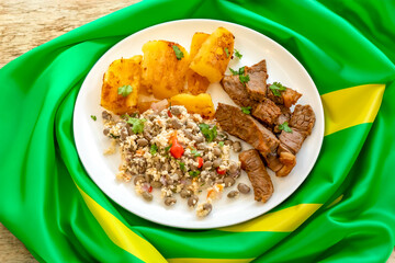 Traditional rustic tropical Brazilian dish, sun-dried beef with green beans, cassava, biquinho pepper. Creative rustic photography