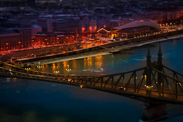 The magic panorama of the city at dusk, river, bridge and city lights. Budapest Hungary, tilt-shift effect, toned