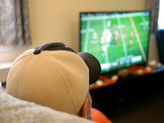 An elderly mans head watching a blurry football game in apartment © Joey