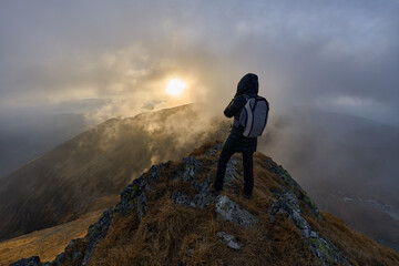 Woman with camera hiking on a trail in the mountains