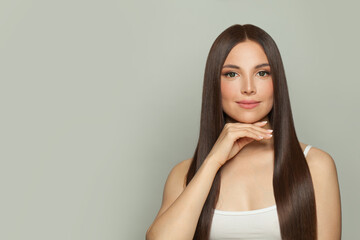 Elegance young woman model with natural make-up and long straight brown hair portrait. Facial treatment, cosmetology, skin care and beauty salon concept