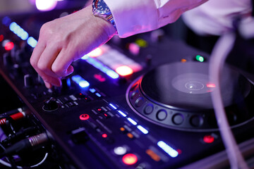 Hand eines Discjockeys am Mischpult