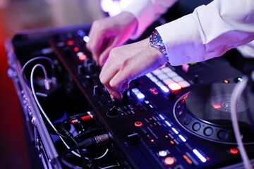Hand eines Discjockeys am Mischpult
