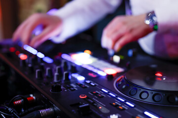 Hand eines Discjockeys am Mischpult