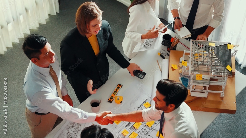Poster top view of skilled architect engineer team inspect house model while project manager hold blueprint