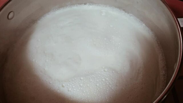 milk boils in a metal pan