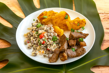 Traditional rustic tropical Brazilian dish, sun-dried beef with green beans, cassava, biquinho pepper. Creative rustic photography