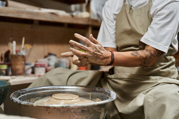A passionate mature woman crafts a beautiful piece of pottery, showcasing her artistic talent.